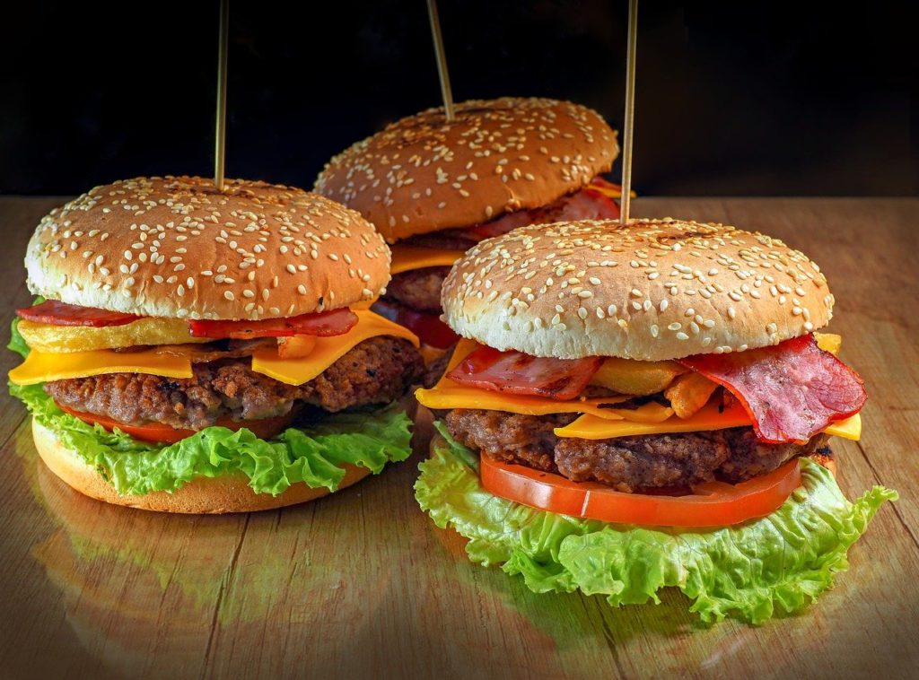 Three burgers with toppings