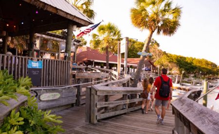 Murrells Inlet, South Carolina, USA-July 14, 2018. The MarshWalk, located in historic fishing village. People walking on wooden boardwalk on the marsh next to restaurants, bars and boats.